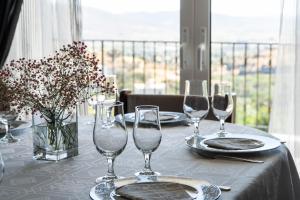 una mesa con copas de vino y un jarrón de flores en Zinovia's Luxury House, en Caristo