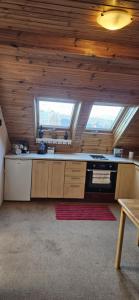 a large kitchen with wooden ceilings and a stove at Apartmán Siuzen in Brezno