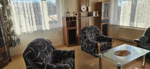 a living room with two chairs and a table at Apartmán Siuzen in Brezno