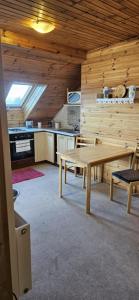 a dining room with a table and a kitchen at Apartmán Siuzen in Brezno
