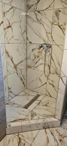 a bathroom with a shower with marble walls at Apartmán Siuzen in Brezno