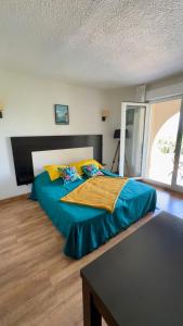 una camera da letto con un letto con un piumone blu di Saint-Florent studio vue piscine a Saint-Florent