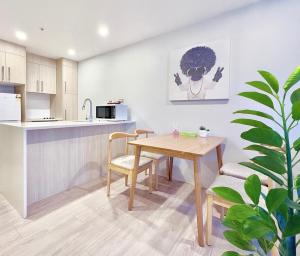 eine Küche und ein Esszimmer mit einem Holztisch und Stühlen in der Unterkunft 2BR Apt Next to Sky Tower with Pool Gym Access in Auckland