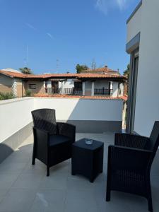 a patio with chairs and a table and a house at TheGlassHouse LIDO in Venice-Lido