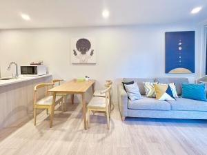 ein Wohnzimmer mit einer blauen Couch und einem Tisch in der Unterkunft 2BR Apt Next to Sky Tower with Pool Gym Access in Auckland