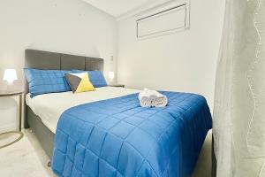 ein Schlafzimmer mit einem blauen Bett mit Handtüchern darauf in der Unterkunft 2BR Apt Next to Sky Tower with Pool Gym Access in Auckland + 12 Fotos