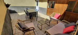 a patio with a table and chairs and a table and a table and chairs at Maison au calme avec terrasse, climatisé in Vertaizon +4 photos