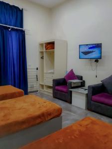 Una sala de estar con dos camas y un televisor. en زافيرو محطه الرمل للعائلات فقط - families only, en Alejandría 44 fotos más