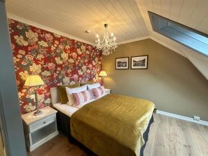 a bedroom with a bed and a chandelier at Hofslund Fjord Hotel in Sogndal +116 photos