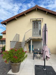 a house with a pink umbrella in front of it at Gîte de brizolles in Cluny