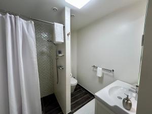 une salle de bain blanche avec une douche et un lavabo dans l'établissement La Villa de Chinon, à Chinon