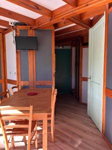 a dining room with a wooden table and chairs at Camp Les Deux in Jouillat