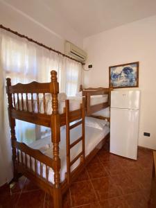 two bunk beds in a room with a refrigerator at Villa Edi in Vlorë