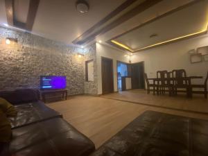 a living room with a couch and a tv at BIZI HOMES in Kigali