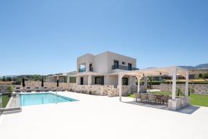 Blick auf eine Villa mit einem Pool in der Unterkunft Villa Jaubelli Bliss in Platánion