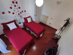 a room with two beds with red sheets at Spacious 3Bedroom Apartment in Nardò, Apulia, Balcony, AC, Wi-Fi in Nardò