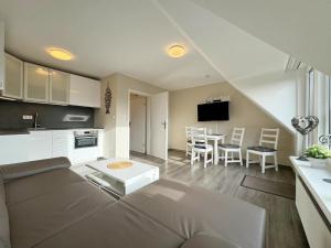 un salon et une cuisine avec un canapé et une table dans l'établissement Ferienwohnung in Tinnum mit Balkon, à Tinnum 12 autres photos