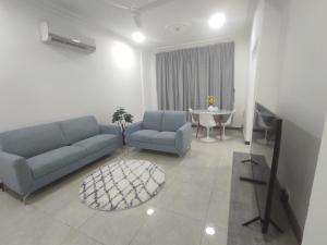 a living room with a couch and a table at Elegant Ap in Muscat