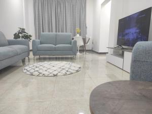 a living room with two chairs and a television at Elegant Ap in Muscat +1 photo