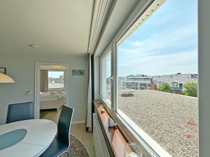 a room with a table and chairs and a large window at Dreizimmerwhg im Zentrum Westerland, Hanseatenhaus App 34 Balkon und Garage in Westerland (Sylt)