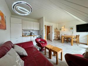 a living room with a red couch and a table at Ferienwohnung in Tinnum auf Syt in Tinnum