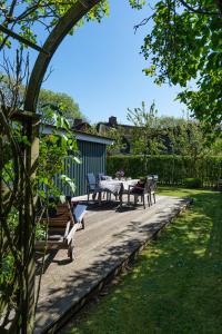 a patio with a table and chairs in a yard at Blä Wening in Borgsum