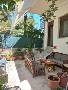 a patio with a couch and tables and potted plants at Peti's Apartment in Prinos