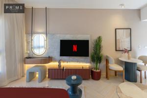 a living room with a tv on a wall at Prime Residence Zayed Hills in Sheikh Zayed