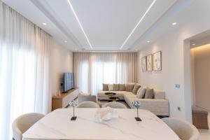 ein Wohnzimmer mit zwei Tischen und einer Couch in der Unterkunft Villa Jaubelli Bliss in Platánion