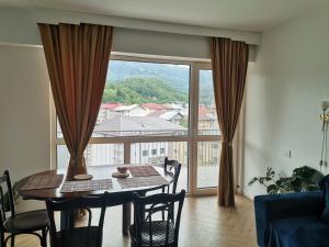 a dining room with a table and a large window at Perla Sinaia in Sinaia