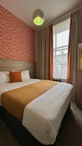 Un dormitorio con una cama grande y una ventana en Cairn Hotel & Apartments, en Edimburgo 82 fotos más