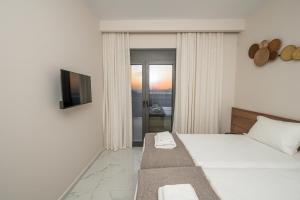 Zimmer mit einem Bett, einem TV und einem Fenster in der Unterkunft Villa Jaubelli Bliss in Platánion + 41 Fotos