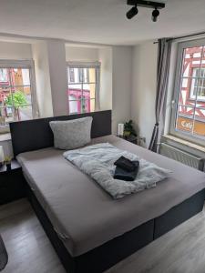 a bedroom with a bed with a blanket and two windows at FeWo Innenstadt mit Parkplatz in 200m Entfernung bis 4 Personen, 80m bis Markplatz in Cochem