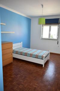 a bedroom with a bed and a dresser and a window at Apartamento T2 Alpiarça in Alpiarça