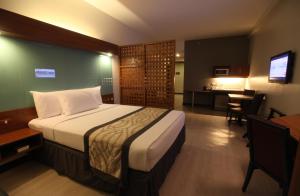 A bed or beds in a room at Microtel by Wyndham UP Technohub
