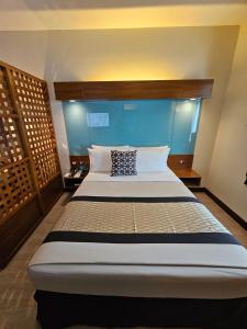 A bed or beds in a room at Microtel by Wyndham UP Technohub