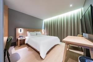 a bedroom with a large white bed and a desk at Healasis in Seongnam