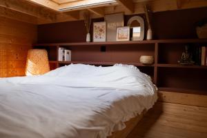 a bedroom with a white bed and shelves at Tiny House Mayu - Veluwe Airco 4 persons in Arnhem