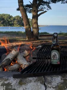 a bottle of beer sitting next to a fire at Schwedenhaus Alleinlage in Bergkvara