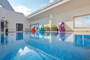 a swimming pool with blue water in a building at Jannah Burj Al Sarab in Abu Dhabi