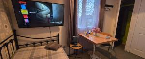 a bedroom with a bed and a table and a tv on the wall at Asal Family House in Fife