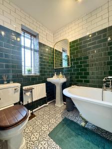 a bathroom with a tub and a toilet and a sink at 29 The Lodge Boutique Grand Victorian Guest House Near Southampton Cruise Terminal, City Centre & The New Forest National Park - FREE PARKING - HIGH SPEED WIFI in Southampton