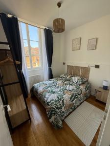 a bedroom with a bed and a large window at L ancien presbytere in Avallon