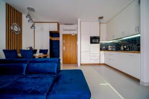 a living room with blue couches and a kitchen at Lulu Apartments - DEEP BLUE LAGOON apartament dwupokojowy - parking, Netflix - 350m od plaży! in Grzybowo