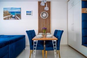 a dining room with a table and blue chairs at Lulu Apartments - DEEP BLUE LAGOON apartament dwupokojowy - parking, Netflix - 350m od plaży! in Grzybowo +10 photos