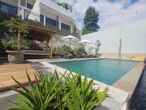 a swimming pool in front of a building at DHM Hotel in Kuta Lombok