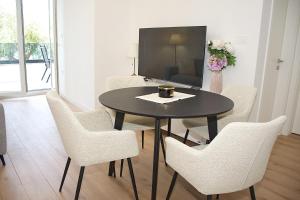 a dining room with a table and chairs and a tv at Tramonto Suite in Novalja