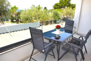 a blue table and two chairs on a balcony at Tramonto Suite in Novalja