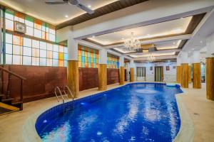 a large pool in a room with stained glass windows at The Kurki Heritage in Jaipur