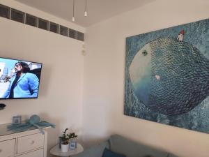 een tv aan de muur met een foto erop bij Casa Vacanze Pesce Palla in Villaggio Azzurro